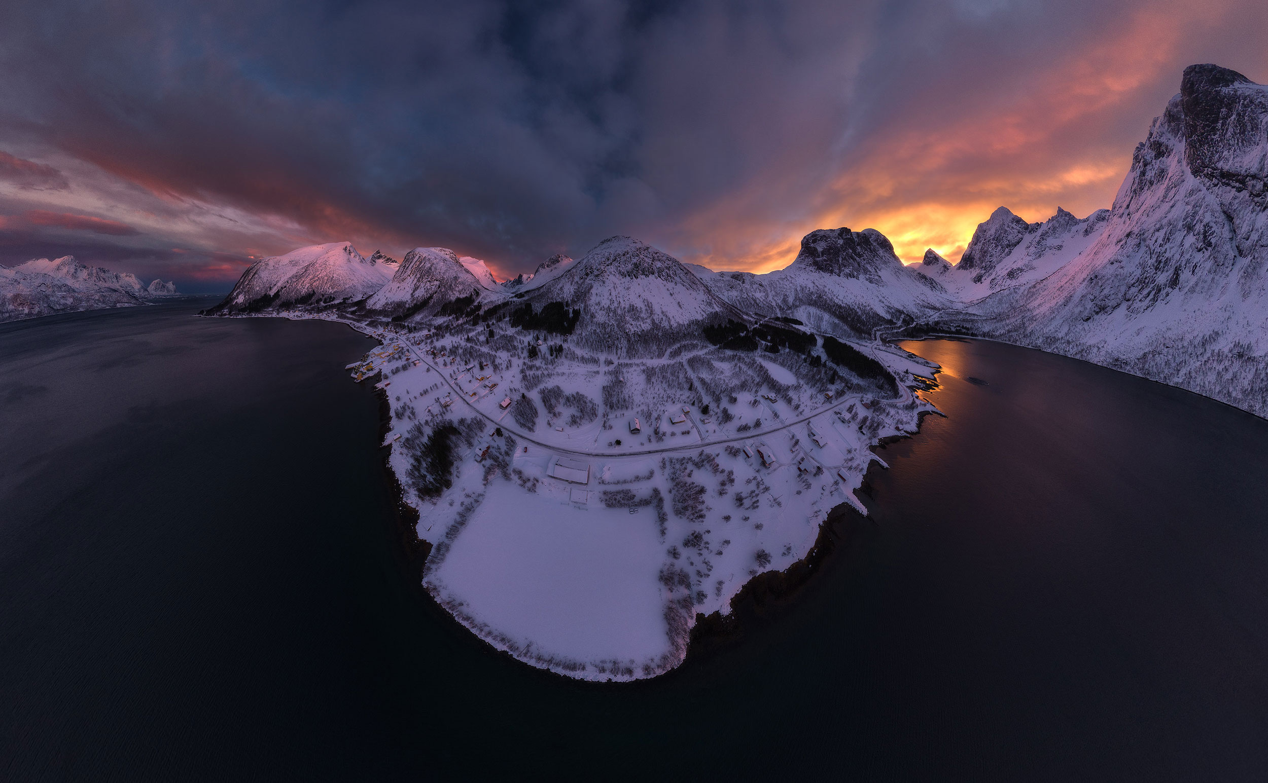 Vista aérea de un pueblo costero nevado al amanecer. Ideal para practicar la exposición en contraluz con el dron.